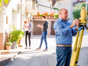 Surveyor conducting a residential land survey in a neighborhood to confirm property boundaries